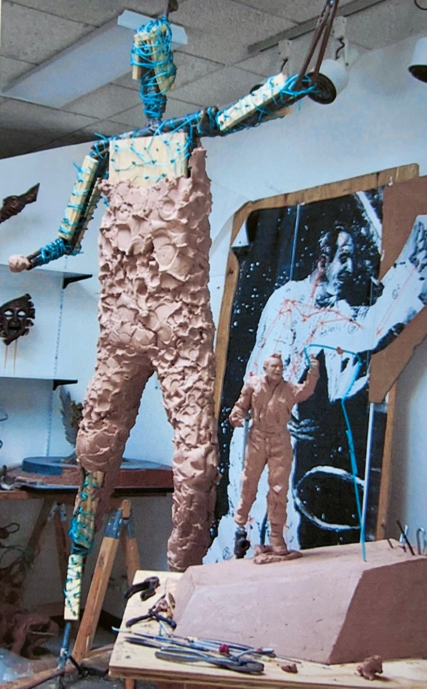   A metal armature is built with supports at points of weight or stress. Wet clay is then pounded on the armature creating the beginning form. Note the maquette in the early stages, and the artists’ drawings